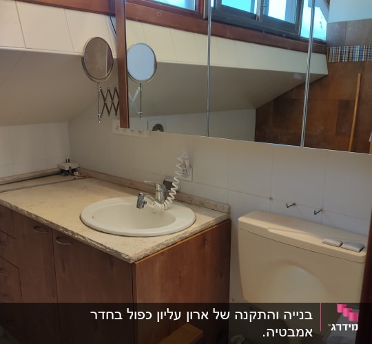 ארון עץ עם כיור ומראה בחדר אמבטיה
